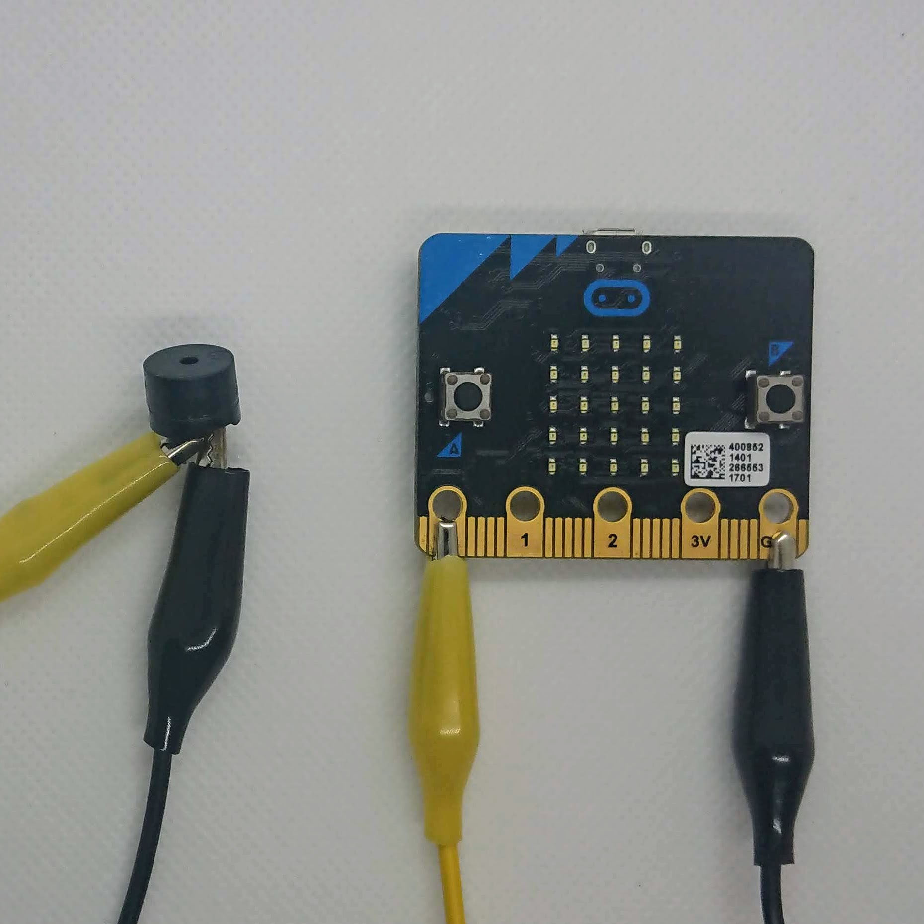 Photograph of a micro:bit with crocodile clips attached to 0 and GND.